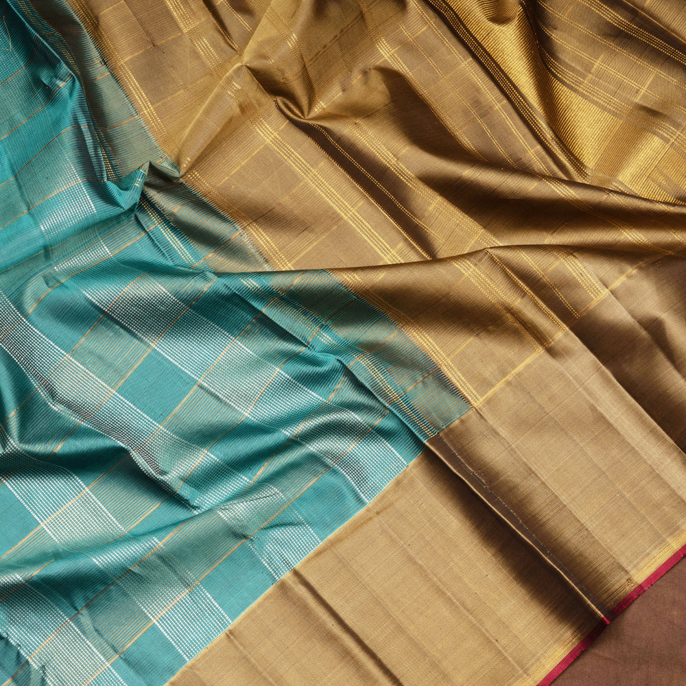 Aqua blue Kanjivaram silk saree with gold and silver zari checks, taupe brown temple border and matching blouse