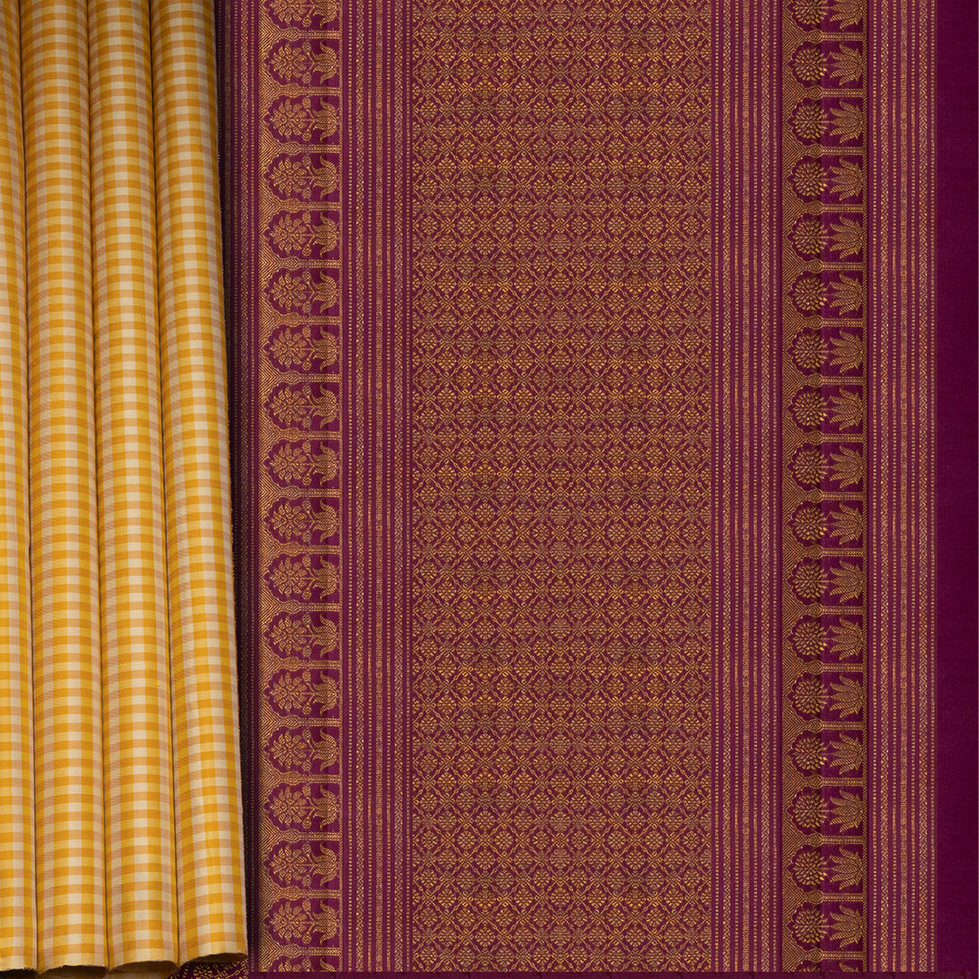 Beige and yellow small checked Kanjivaram silk saree with purple pallu featuring floral motifs, chevron and chakram designs, paired with dotted butta blouse.