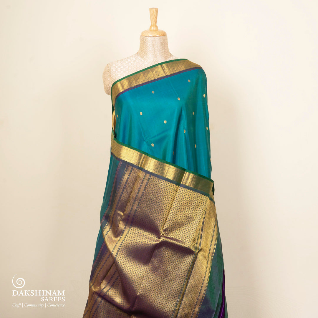 Peacock blue Kanjivaram silk saree with floral butta, dark blue zari border and diamond panel pallu with matching blouse