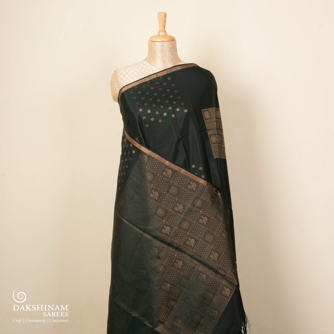 Dark green soft silk saree with gold and silver zari annam, chakram and floral motifs