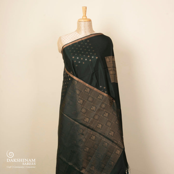 Dark green soft silk saree with gold and silver zari annam, chakram and floral motifs