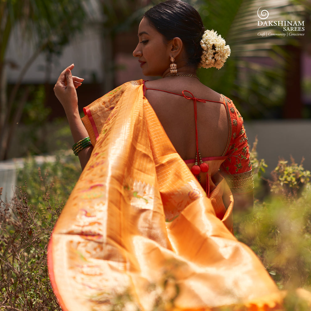 Orange Kanjivaram silk saree with checkered body, Paithani lotus vine and parrot border, pink selvedge and traditional pallu.