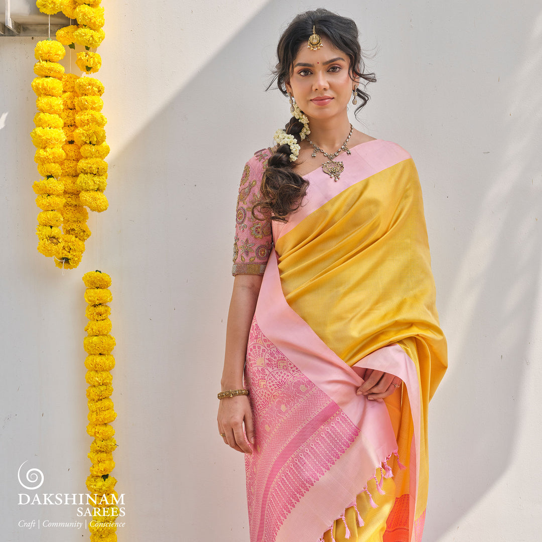 Yellow soft silk saree with self textured body and baby pink pallu with floral vine and lotus zari design