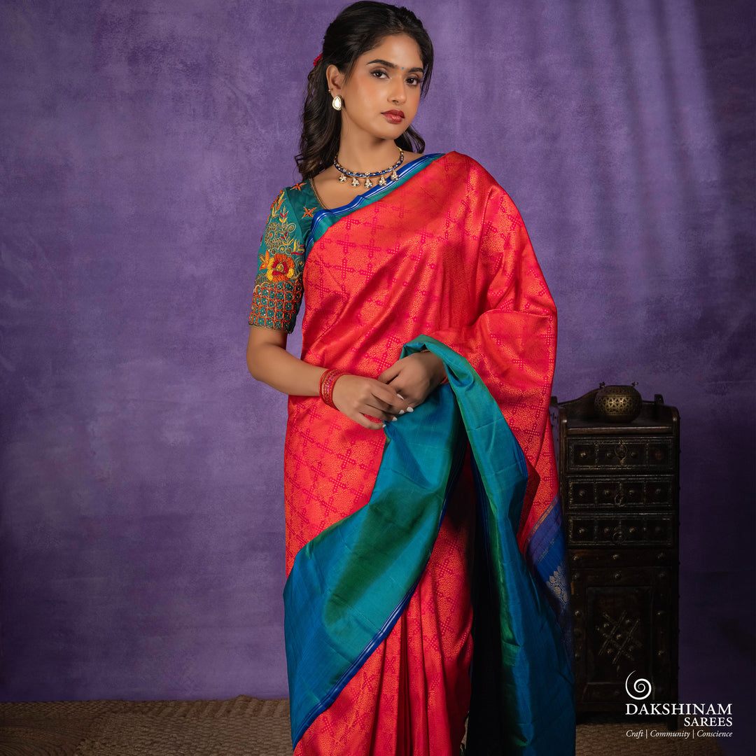 Orange no-zari Kanjivaram silk saree with light orange thread detailing, peacock green long border with silver zari lines, peacock blue pallu and matching blue blouse.