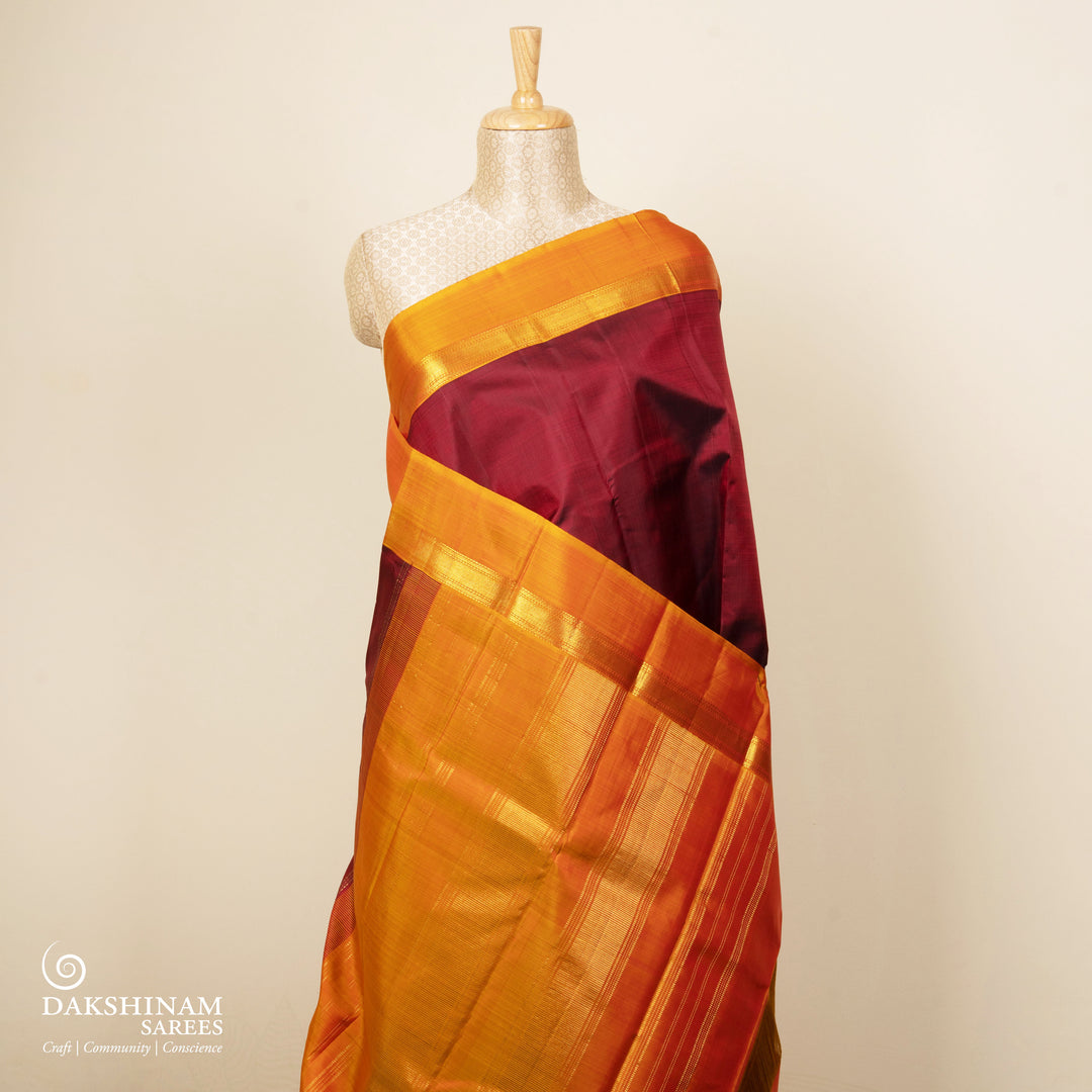 Maroon handwoven Kanjivaram silk saree with mango yellow border, gold zari and contrast pallu