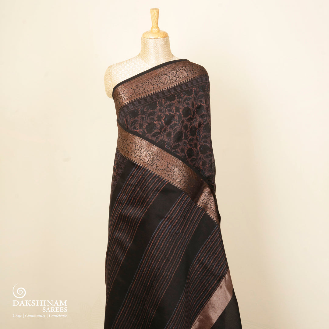 Black Chanderi silk cotton saree with white floral print, brown zari border and striped pallu