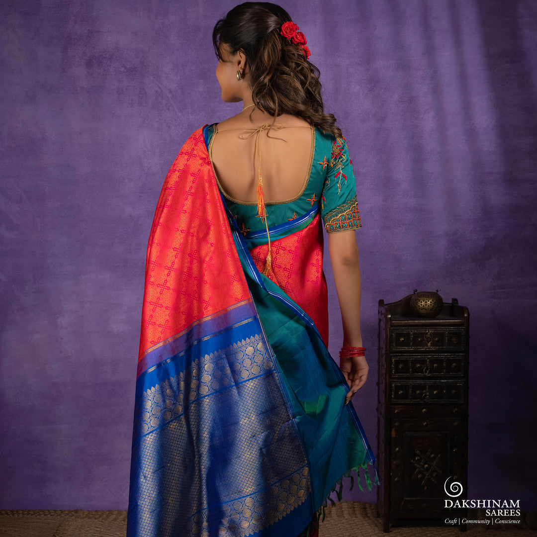 Orange no-zari Kanjivaram silk saree with light orange thread detailing, peacock green long border with silver zari lines, peacock blue pallu and matching blue blouse.