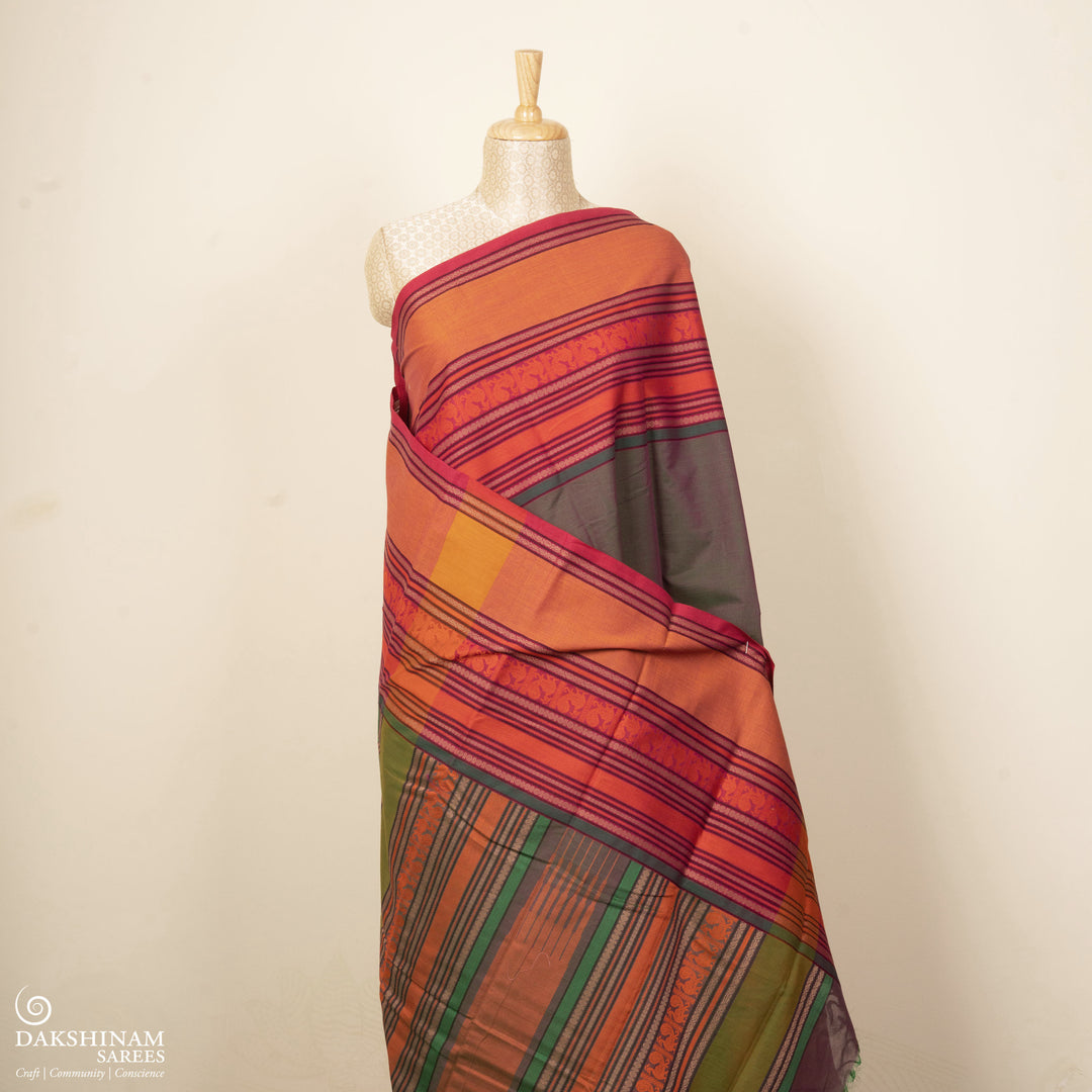 Green handwoven cotton saree with orange and brown border, peacock motifs and traditional pallu